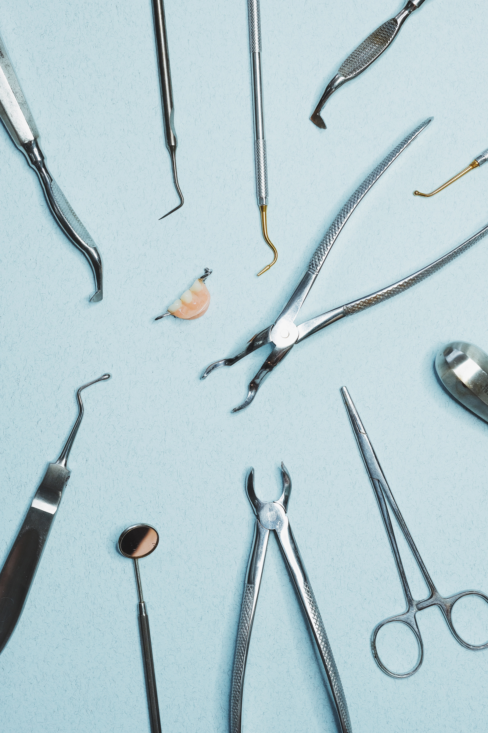 Stainless Dental Tools on Blue Surface